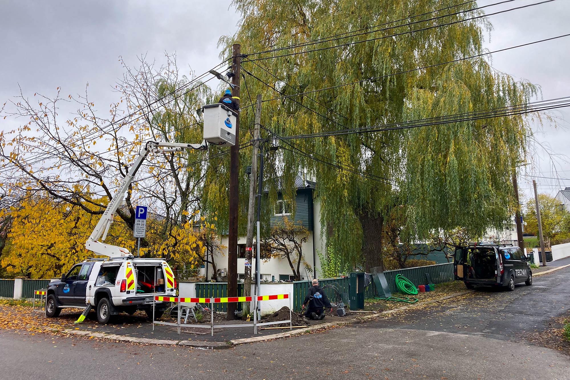 Tecnia AS - Liftbil og tekniker ved telekommunikasjonsstolpe på boligområde